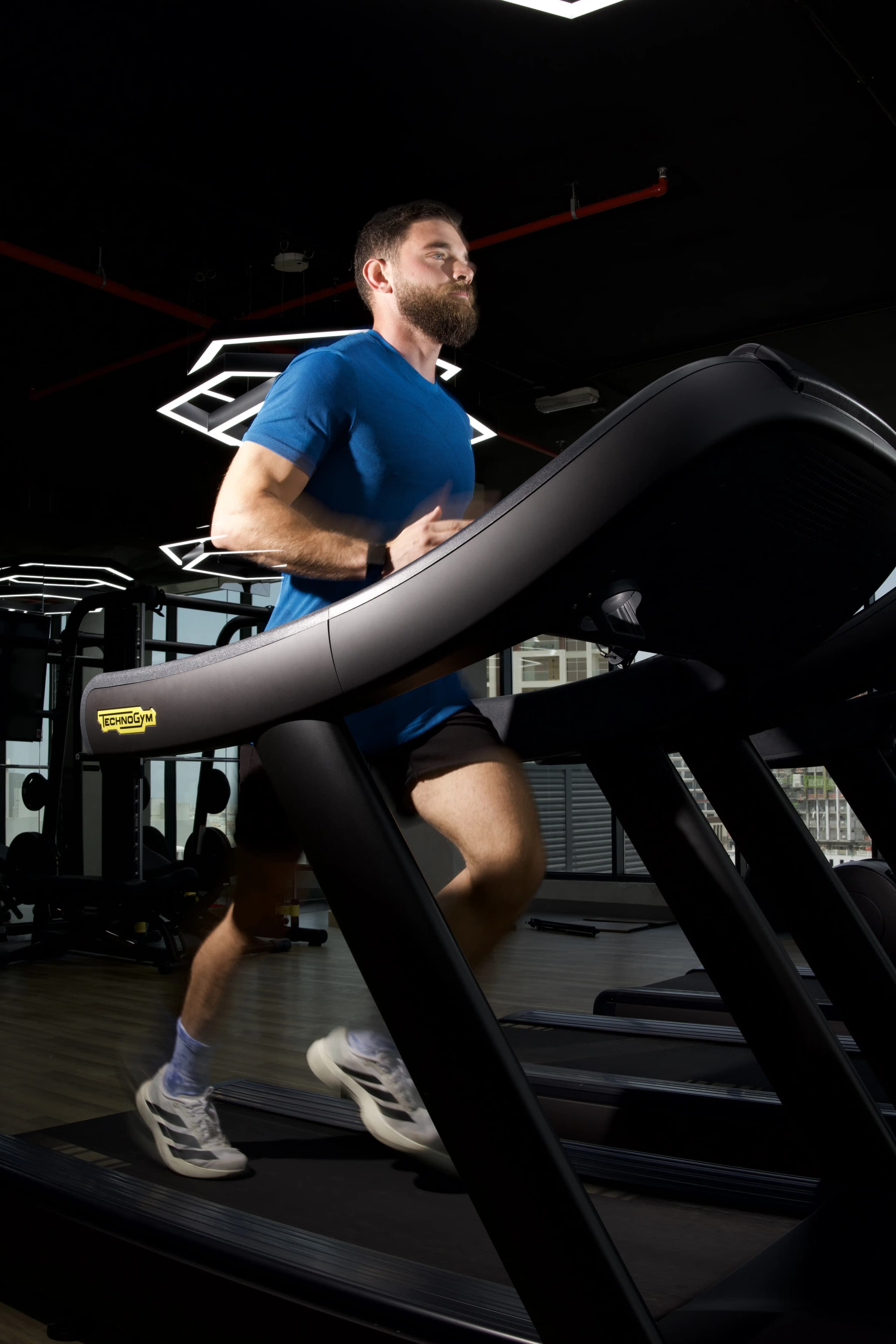 Athlete running on a treadmill during HYROX race preparation training.