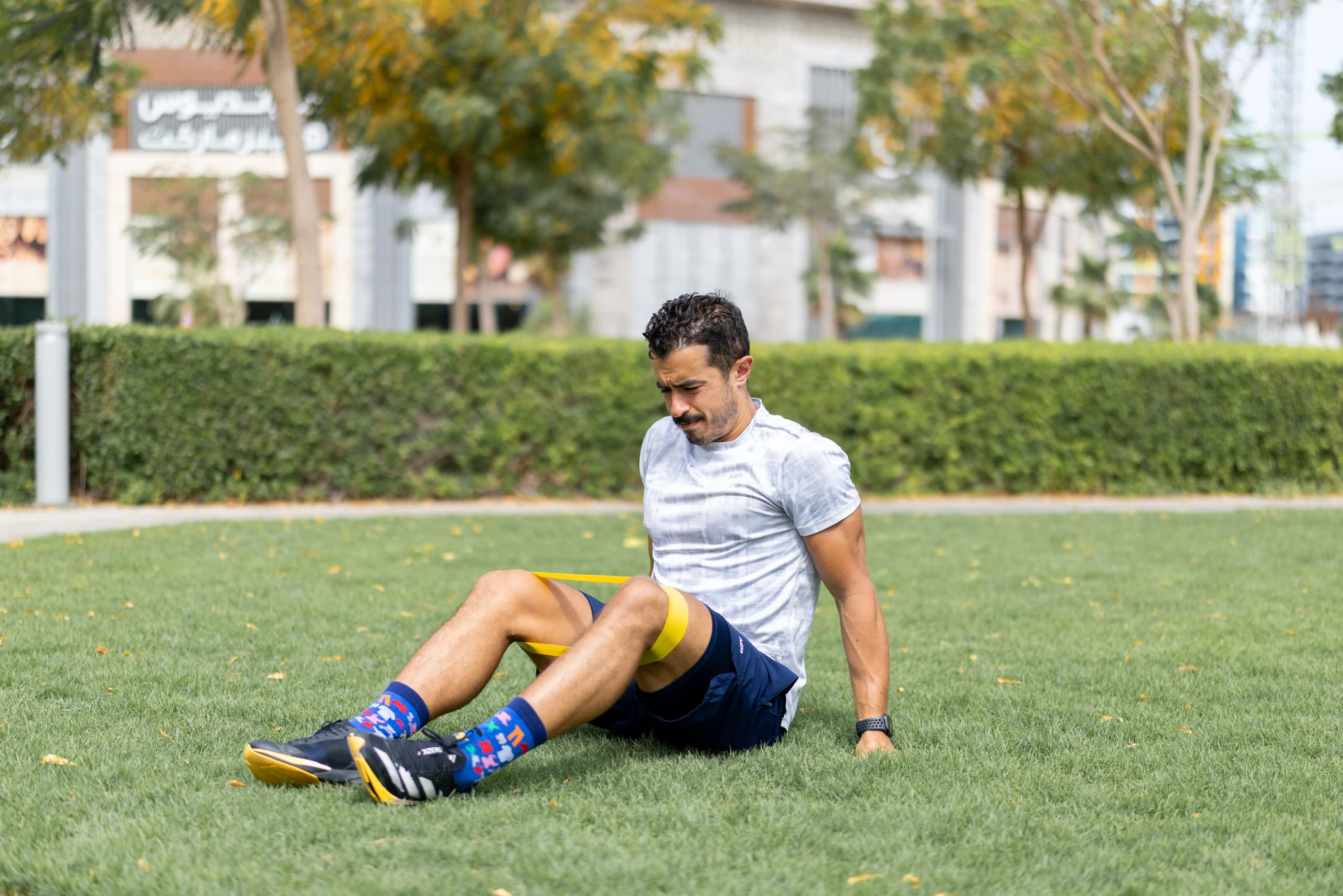 Man stretching leg outdoors during recovery session after workout in a park