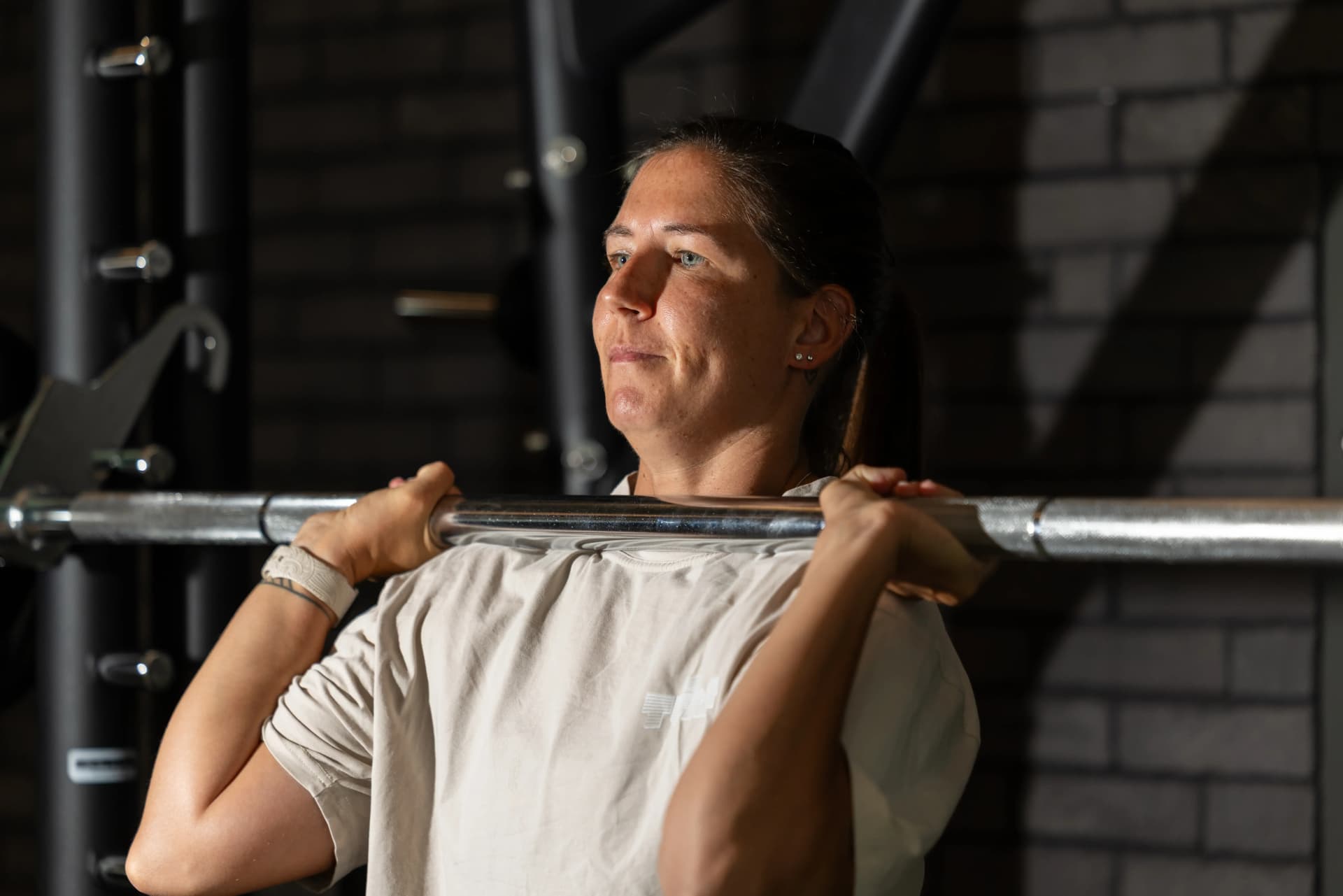 Female athlete resting between strength training sets in a gym environment