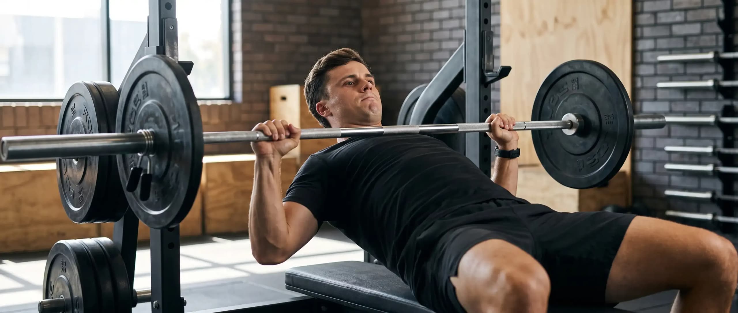Man performing a barbell bench press during an upper-body strength workout