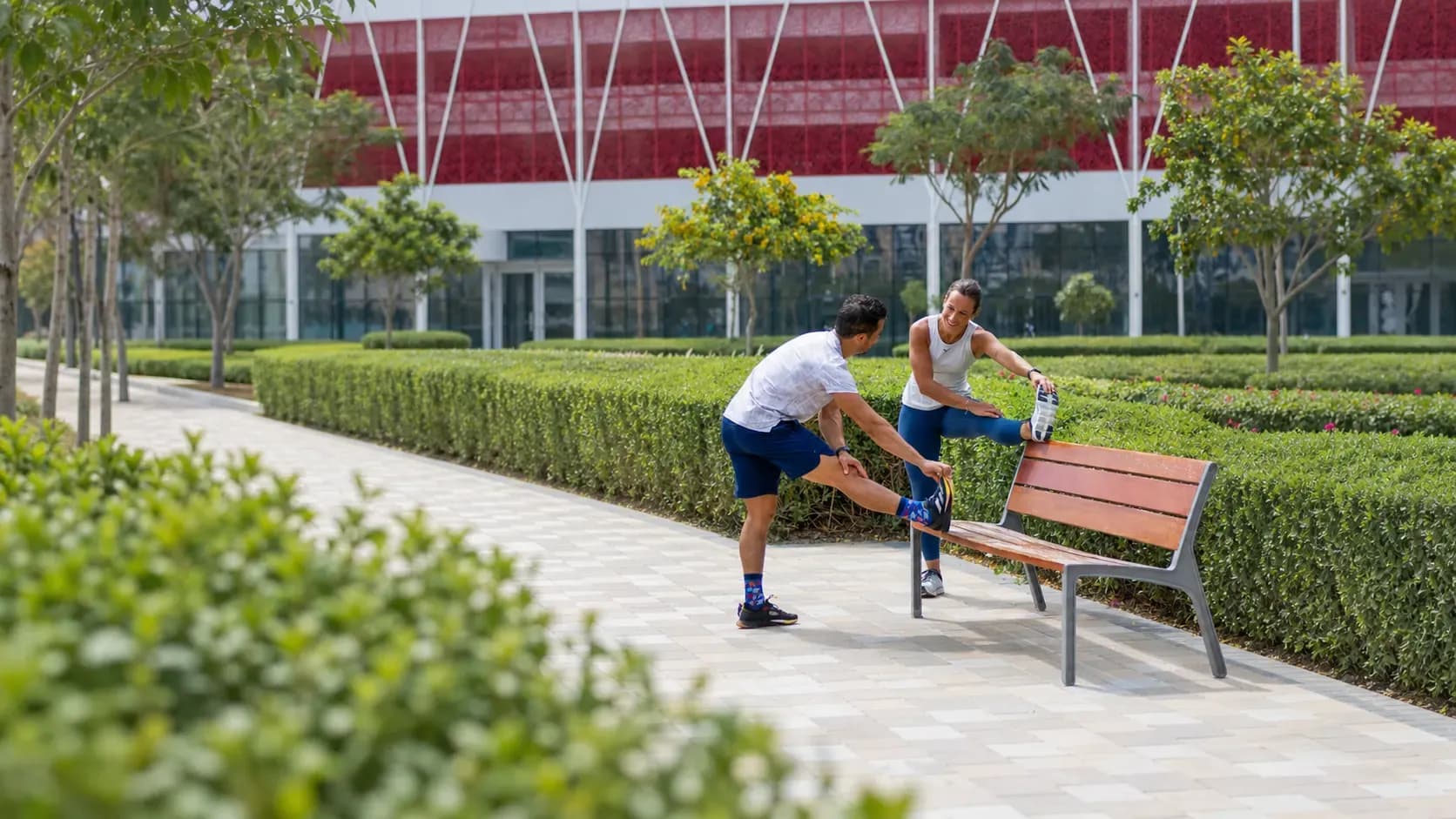 Personal trainer coaching client outdoors demonstrating proper exercise technique